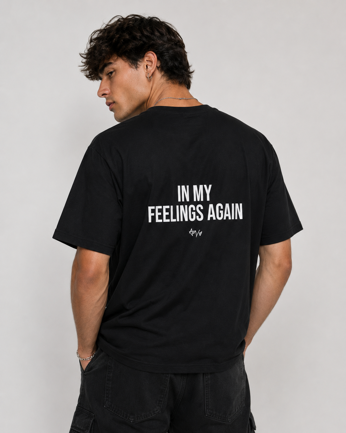 Person wearing a black t-shirt with text on the back against a plain background