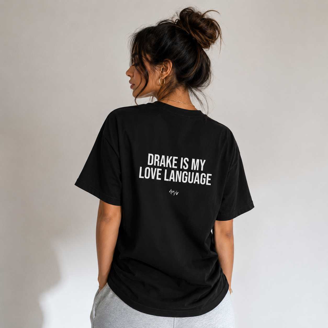 Person wearing a black t-shirt with 'Drake is my love language' text on the back.